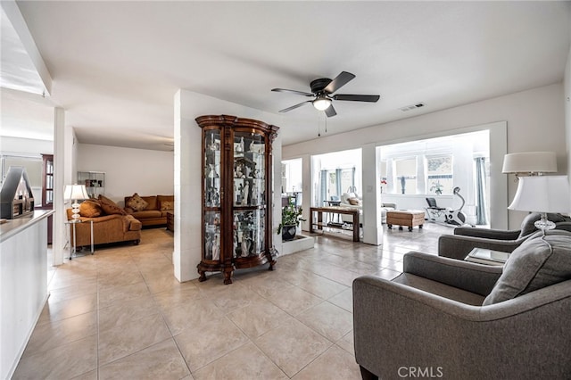 living area with visible vents, ceiling fan, and light tile patterned floors