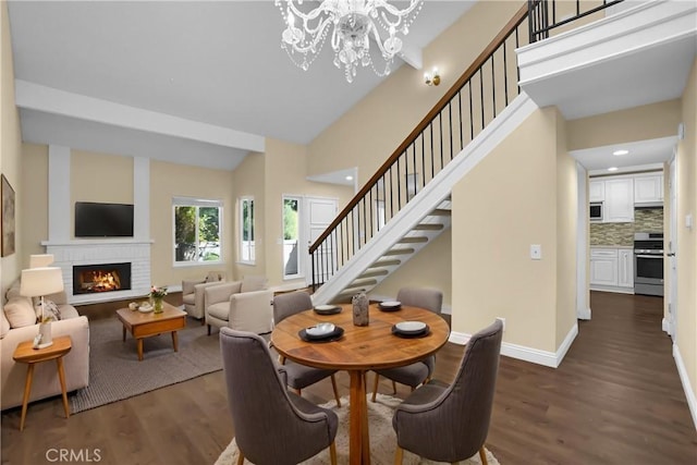 dining room with stairs, baseboards, dark wood-style floors, and a fireplace