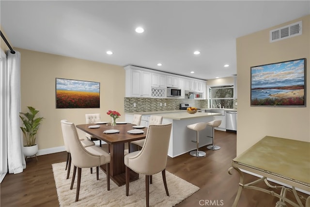 dining space featuring visible vents, recessed lighting, baseboards, and dark wood-style floors