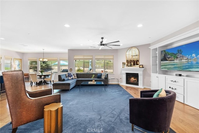 living area with recessed lighting, a lit fireplace, and plenty of natural light