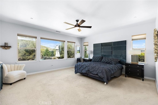 bedroom featuring baseboards, light carpet, and multiple windows