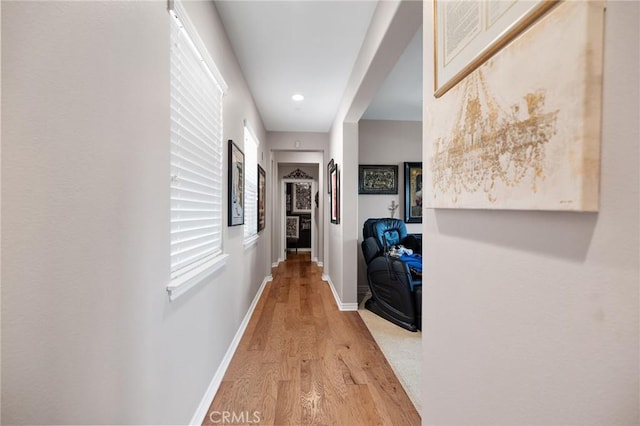 hallway featuring recessed lighting, baseboards, and light wood-type flooring