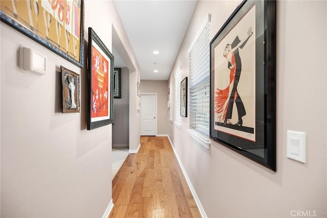 corridor featuring recessed lighting, light wood finished floors, and baseboards