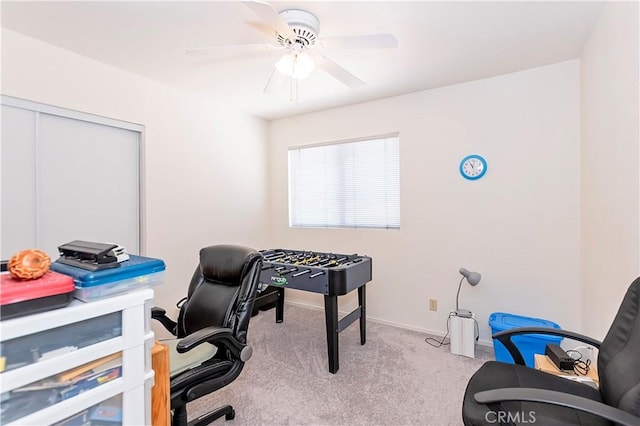 carpeted office with a ceiling fan and baseboards