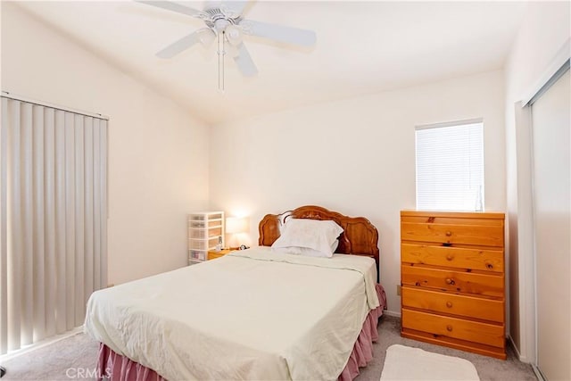 bedroom with light colored carpet, ceiling fan, lofted ceiling, and a closet