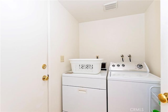 laundry area with laundry area, washer and clothes dryer, and visible vents