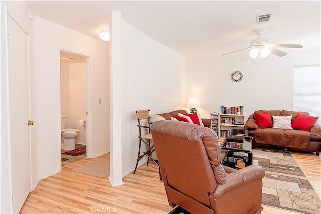 living area featuring visible vents, light wood finished floors, and ceiling fan