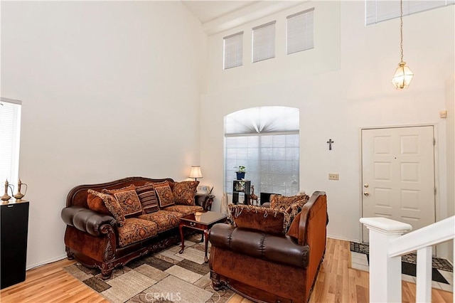 living area featuring light wood-style floors and a towering ceiling