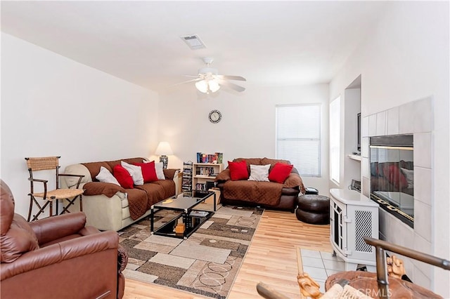 living area with a ceiling fan, light wood-type flooring, and visible vents