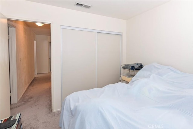bedroom featuring light carpet, a closet, and visible vents