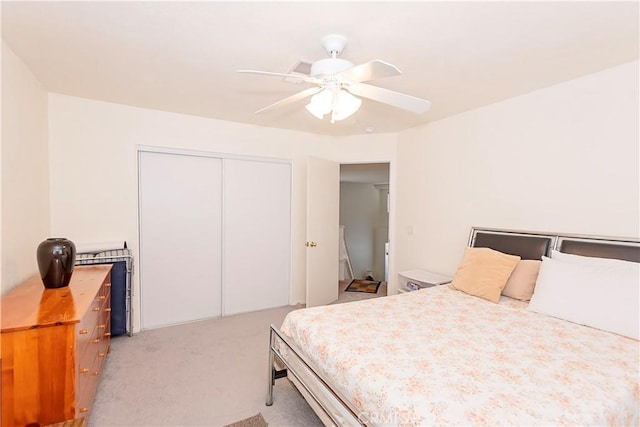 bedroom featuring ceiling fan, a closet, and light colored carpet