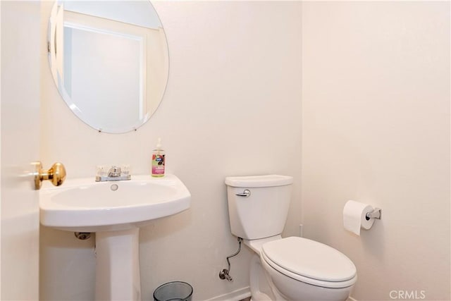 bathroom featuring toilet and baseboards
