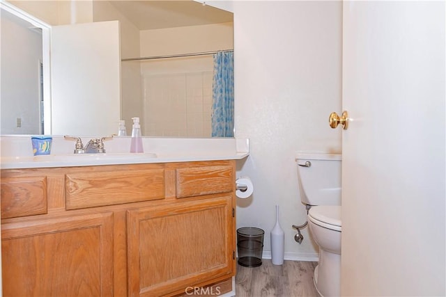 bathroom featuring vanity, wood finished floors, curtained shower, toilet, and baseboards