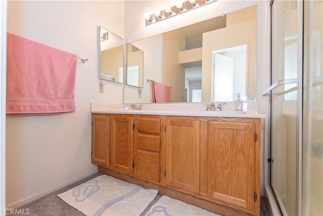 bathroom featuring double vanity, baseboards, a sink, and a stall shower