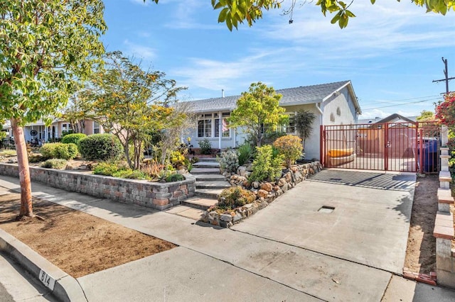 ranch-style home featuring a gate, stucco siding, and fence