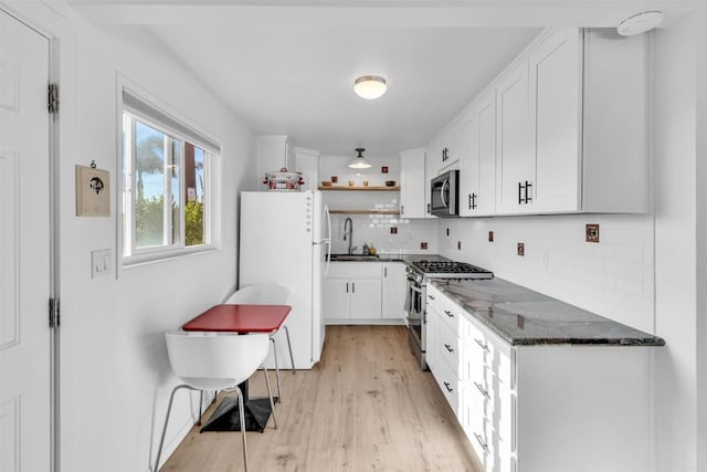 kitchen with open shelves, light wood-style floors, white cabinets, a sink, and stainless steel appliances