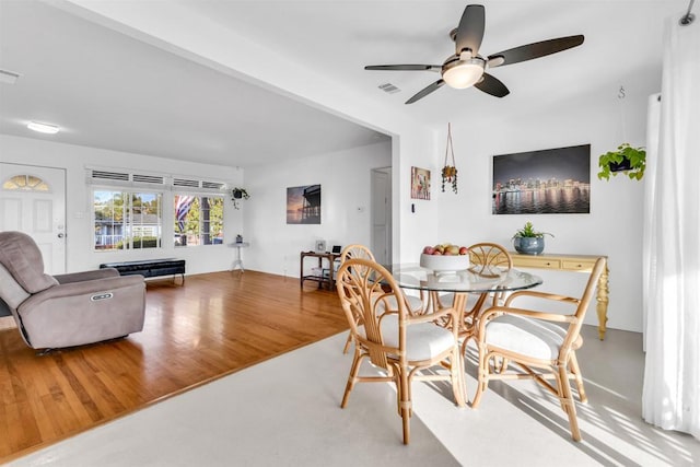 dining area featuring visible vents, ceiling fan, and wood finished floors