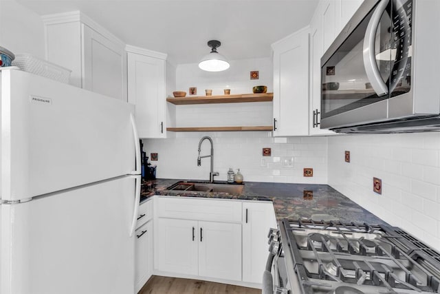 kitchen featuring white cabinets, backsplash, and stainless steel appliances