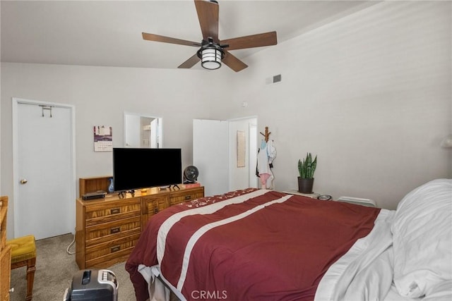carpeted bedroom with visible vents, ceiling fan, and vaulted ceiling