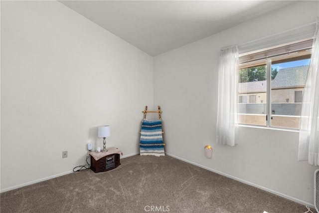 unfurnished room featuring baseboards, carpet, and vaulted ceiling