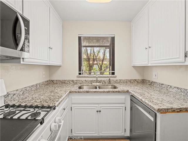kitchen featuring a sink, stainless steel appliances, and white cabinetry