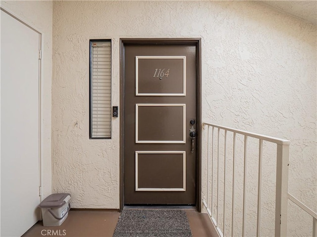 entrance to property featuring stucco siding