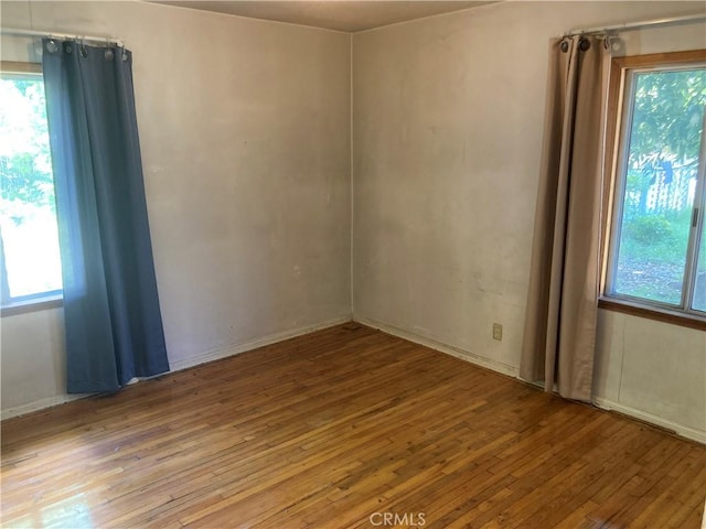 unfurnished room featuring plenty of natural light and hardwood / wood-style floors
