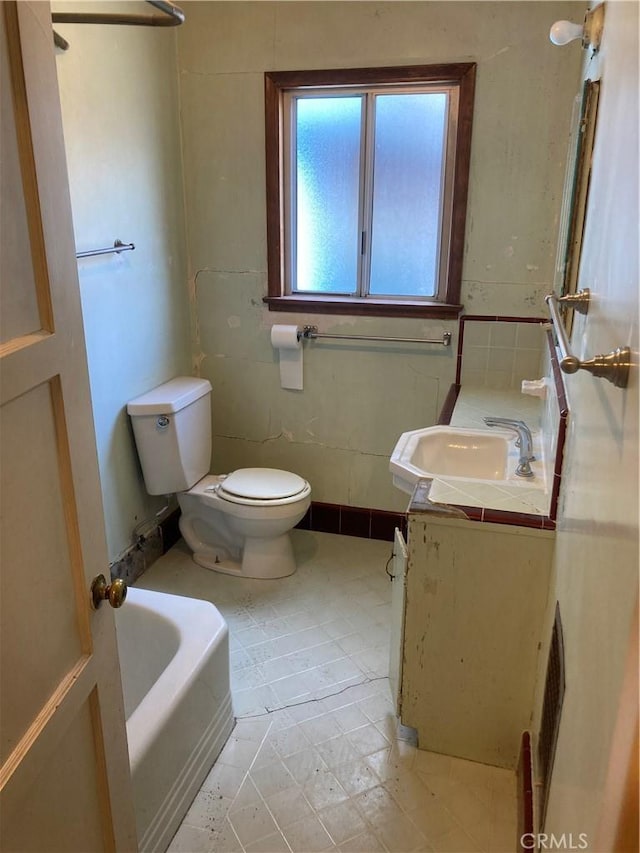 full bathroom with toilet, a washtub, and vanity
