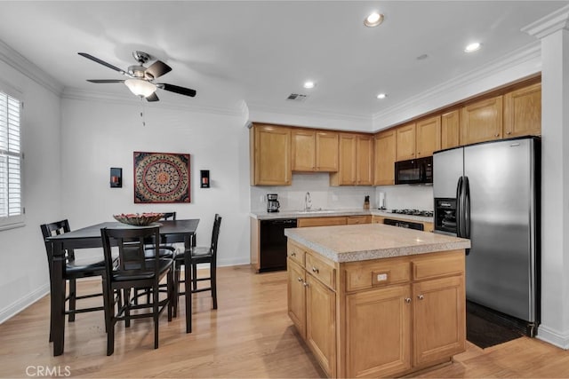 7132 Farralone Ave Unit 203, Canoga Park, CA 91303 - kitchen with light countertops, a center island, a ceiling fan, visible vents, and black appliances