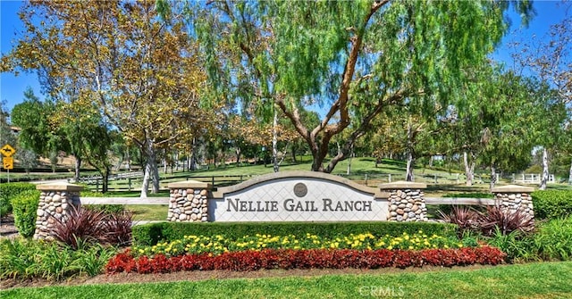 community / neighborhood sign featuring view of wooded area