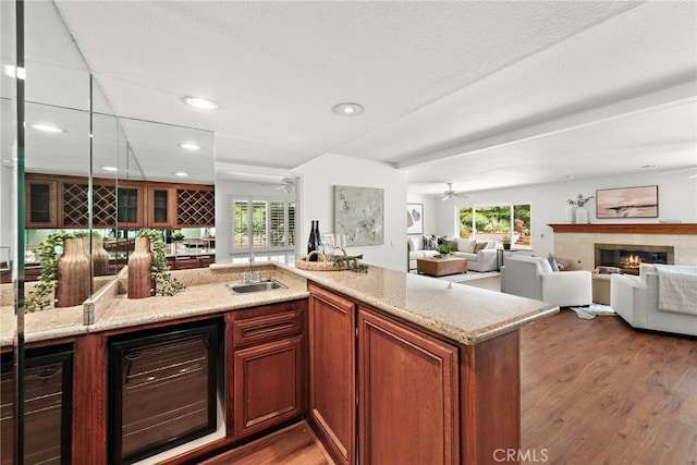 kitchen with wood finished floors, plenty of natural light, a fireplace, and wine cooler