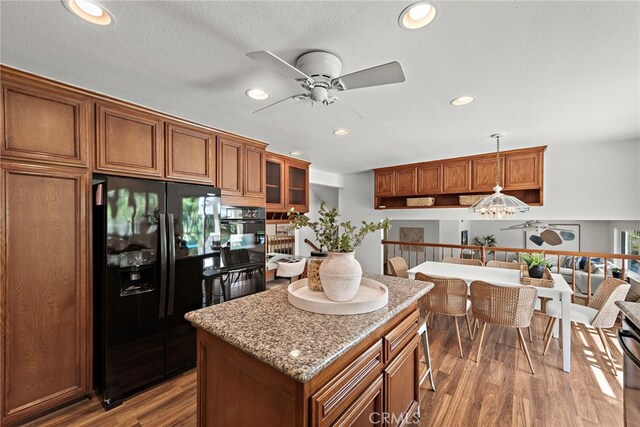 25122 Black Horse Ln, Laguna Hills, CA 92653 - kitchen with black fridge with ice dispenser, ceiling fan, brown cabinets, wood finished floors, and a kitchen island