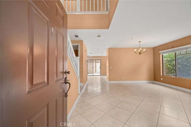 entrance foyer featuring light tile patterned floors, baseboards, visible vents, and a notable chandelier