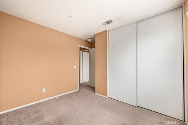 unfurnished bedroom with visible vents, carpet, baseboards, and a closet