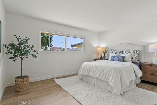bedroom featuring baseboards and wood finished floors