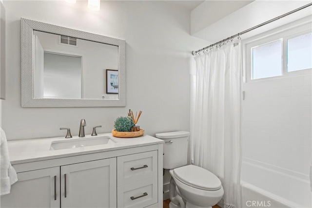 full bathroom featuring vanity, shower / bath combo with shower curtain, toilet, and visible vents