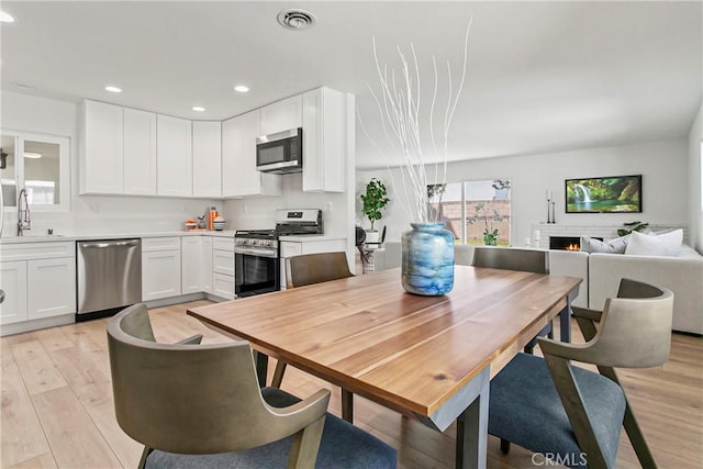 dining space featuring light wood-type flooring, recessed lighting, and visible vents