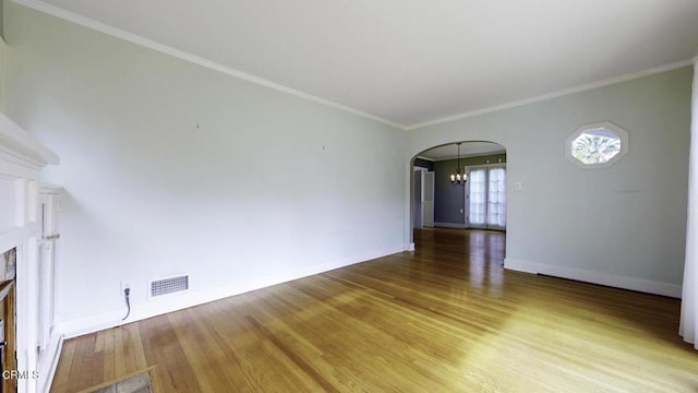 unfurnished living room featuring baseboards, arched walkways, light wood-style flooring, and visible vents