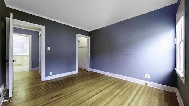 interior space with crown molding, baseboards, and wood finished floors