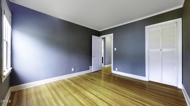 interior space with crown molding, baseboards, and wood finished floors
