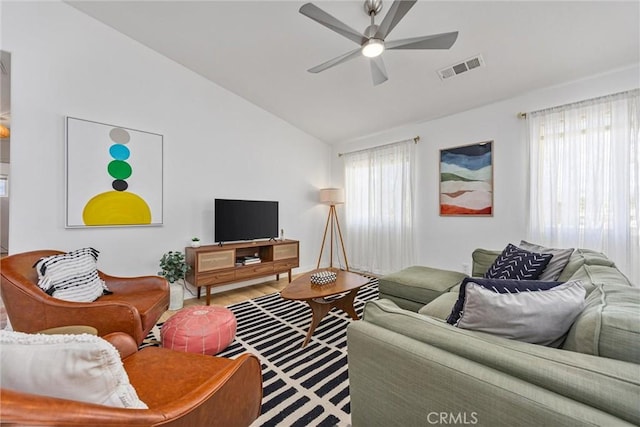 living room featuring wood finished floors, ceiling fan, visible vents, and lofted ceiling