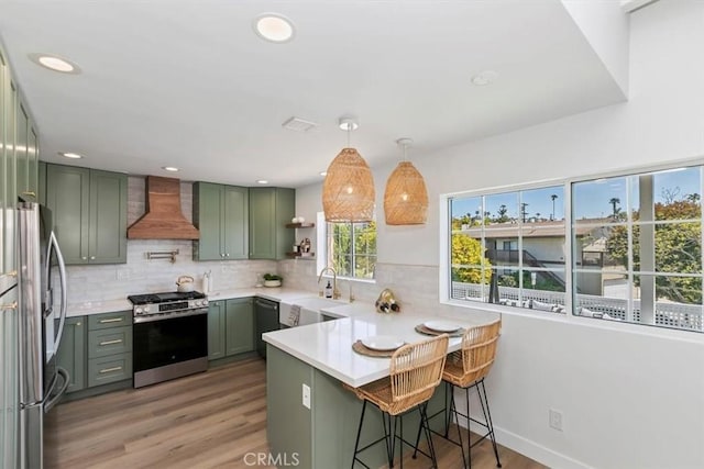 33935 Violet Lantern St, Dana Point, CA 92629 - kitchen with green cabinetry, stainless steel appliances, a peninsula, decorative backsplash, and custom exhaust hood