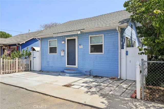 bungalow-style house with fence and roof with shingles