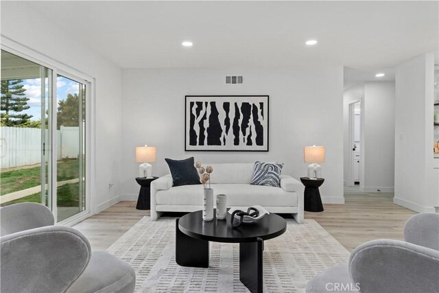living area with baseboards, recessed lighting, light wood-style flooring, and visible vents