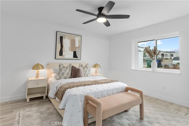 bedroom featuring baseboards, a ceiling fan, and wood finished floors