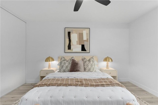 bedroom with baseboards, ceiling fan, and wood finished floors