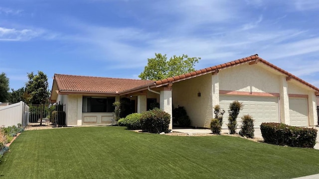 view of front of property featuring a tiled roof, an attached garage, fence, and a front lawn