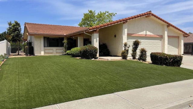 mediterranean / spanish house featuring an attached garage, fence, a tiled roof, and a front yard
