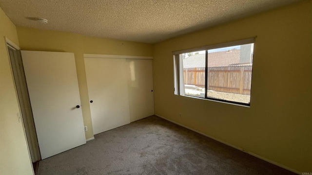 unfurnished bedroom featuring carpet, a closet, and a textured ceiling