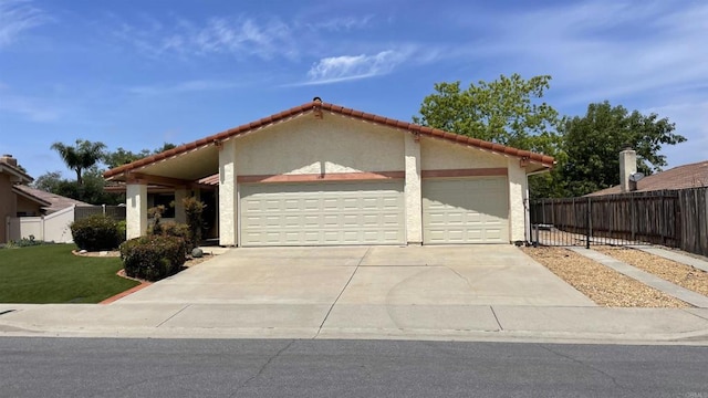 view of front of house with fence, a garage, stucco siding, a front yard, and driveway